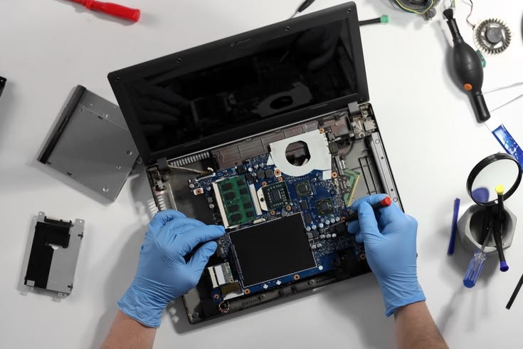 male,technician,with,screwdriver,repairing,laptop,on,table,in,service